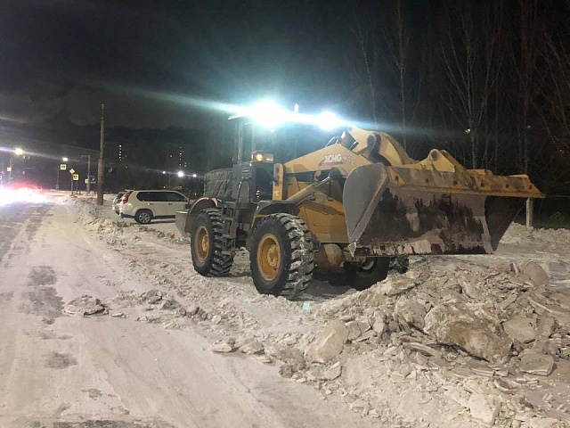 Рабочие и техника ГСТК очищают проезжую часть от наледи в микрорайоне